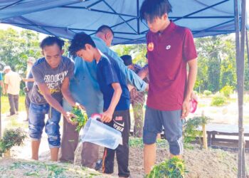 MUHD.  Ikman Hafifi Mohd. Ramdan (kanan) dan adiknya, Muhd. Aiman Danial menyiram kubur ibu dan bapa mereka selepas pengebumian di Tanah Perkuburan Islam Kampung Serkai Jadi, Tronoh dekat Batu Gajah. – UTUSAN/SAYED HESHAM IDRIS