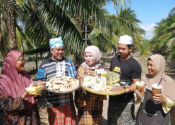 MOHD. Kahni Habsu (dua dari kiri) bersama ahli keluarga menunjukkan pelbagai makanan tradisional berasaskan kelapa yang diusahakan mereka di Kampung Batu Putih, Marang, Terengganu. – UTUSAN/NOOR HAYATI MAMAT