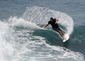 EORANG pelancong meluncur di pantai Uluwatu di Kuta, Bali. - AFP