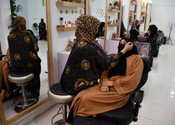SEORANG pakar kecantikan menata rias wajah pelanggannya di sebuah salon kecantikan di Kabul, Afghanistan.-AFP
