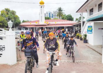 IMAM muda Masjid Pintu Geng, Mohammad Saifullah Yusoff (kiri) mengetuai seramai 60 peserta Kayuhan Maal Hijrah Masjid Mukim Pintu Geng mengelilingi kawasan kampung bagi meraikan sambutan Maal Hijrah 1445H. – UTUSAN/MUSTAQIM MOHAMED