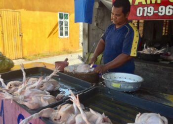 SHUHAIRI Othman memotong ayam yang ditempah pelanggan di kedainya di Kampung Bukit Tok Beng, Seberang Takir, Kuala Nerus, hari ini. - UTUSAN/TENGKU DANISH BAHRI TENGKU YUSOFF