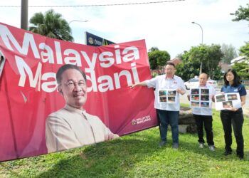 ANDREW Ooi menunjukkan papan iklan Malaysia Madani yang dikesan dipasang di sekitar Pulau Pinang dalam sidang akhbar di Bayan Baru, Pulau Pinang hari ini.