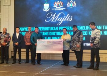 CHOW Kon Yeow (tengah) menerima cek daripada King Sing dalam majlis penyerahan peruntukan program pemeliharaan tapak warisan dunia yang diiktiraf UNESCO kepada Pulau Pinang dan Melaka di George Town, Pulau Pinang, hari ini.