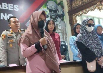 HI (baju merah jambu) memberi keterangan kepada media mengenai tindakannya menjual bayinya di ibu pejabat polis Semarang. - AGENSI