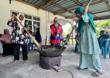 SALMEE Said (dua dari kanan) membantu mengacau bubur Asyura bersama penduduk sewaktu turun padang di Kampung Padang Gelanggang, Sanglang, Kedah. -UTUSAN/ASYRAF MUHAMMAD