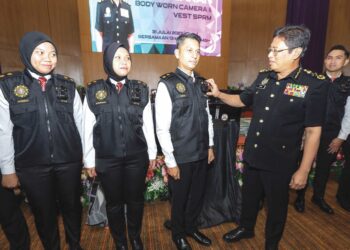 Azam Baki (kanan) menunjukkan kamera badan yang akan digunakan Suruhanjaya Pencegahan Rasuah Malaysia (SPRM) selepas melancarkannya di Putrajaya, semalam.