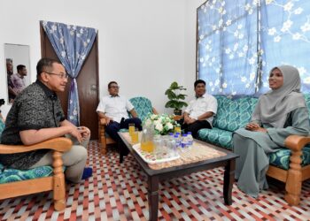 AHMAD Samsuri Mokhtar (kiri) bertanyakan sesuatu kepada  pekerja TDM Plantation yang berjaya memiliki rumah di Ladang Jaya, dekat Sungai Tong di Setiu, hari ini. - UTUSAN/KAMALIZA KAMARUDDIN