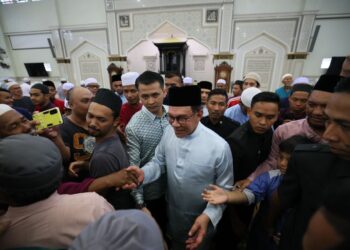 ANWAR Ibrahim (tengah) bersalaman bersama jemaah selepas solat Jumaat di Masjid Sultan Muhammad, Bukit Besar, Kuala Terengganu, hari ini. - UTUSAN/PUQTRA HAIRRY ROSLI