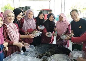 SAYANI Saidon (empat dari kiri) bersama warga bomba Perak membungkus bubur asyura untuk diagihkan dalam Program Bubur Asyura di Ibu Pejabat JBPM Perak di Bandar Meru Raya, Ipoh hari ini. - UTUSAN/ASLIZA MUSA