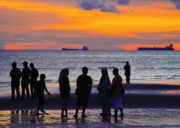 PENGUNJUNG tidak melepaskan peluang melihat matahari terbenam dengan laluan kapal-kapal besar menelusuri Selat Melaka yang dirakam kira-kira pukul 7.20 petang semalam daripada Pantai Saujana, Teluk Kemang, Port Dickson.