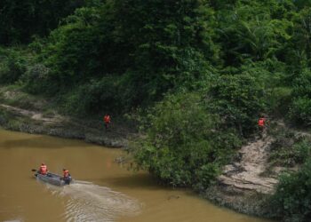 ANGGOTA keselamatan yang menyertai operasi SAR melakukan pencarian mangsa tarakhir tragedi kepala air, Putri Nor Fatin Karim, di Jeram Mawar, Air Putih, Kemaman, hari ini. - UTUSAN/PUQTRA HAIRRY ROSLI