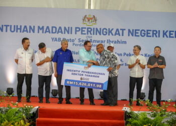 ANWAR Ibrahim (tengah) menyampaikan Sumbangan Insentif Pembangunan Sektor Perikanan dan Tanaman kepada penerima di Majlis Sentuhan Madani Peringkat Negeri Kedah di Ibu Pejabat MADA, Alor Setar. -UTUSAN/ SHAHIR NOORDIN