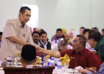 MD. Suhaimi Abd. Rahman (kiri) bersalaman dengan Muhammad Sanusi Md. Nor ketika menghadiri Majlis Penyerahan Geran Daerah Bandar Baharu di Dewan Seri Tasik Pekan Serdang, Bandar Baharu. - UTUSAN/SHAHIR NOORDIN