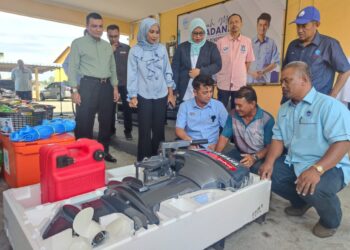 MUHAMMAD Faiz Fadzil (duduk, kanan) memperkatakan sesuatu kepada penerima bantuan enjin bot, Samsudin Embong (duduk, tengah) pada Program Rahmah Mesra Madani, Sesi Libat Urus Bersama Nelayan Negeri Terengganu di Pelabuhan LKIM Chendering, Kuala Terengganu, hari ini.