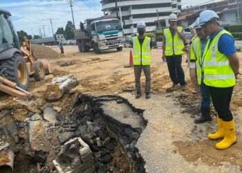 MOHAMAD FAZLI MOHAMAD SALLEH (kanan meninjau kerja-kerja membaik pulih paip air utama yang pecah di persimpangan lampu isyarat Sekolah Menengah Convent di Jalan Kluang-Batu Pahat.