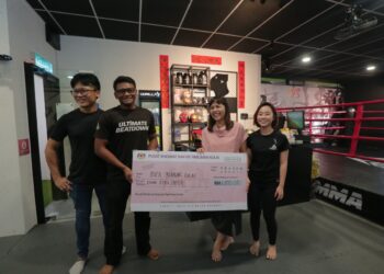 TEO NIE CHING  (dua dari kanan) menyampaikan replika cek sumbangan kepada Mohamad Hisyam di Ultimate MMA Fitness & Self Defence, Kulai.