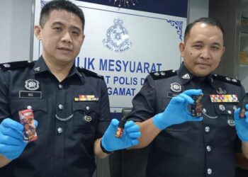 AHMAD ZAMRY MARINSAH  (kanan) menunjukkan sebahagian cecair vape mengandungi jus ganja yang dirampas daripada tiga beranak di Paya Pulai dan Buloh Kasap, Segamat.