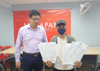 RAYMOND (kanan) ditemani Andrew Chen menunjukkan enam salinan laporan polis yang dibuat terhadap sindiket ah long yang mengugutnya.