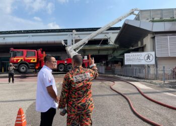 MOHD. HAIRI MAD SHAH (kiri) meninjau operasi memadam kebakaran  di Larkin Sentral, Johor Bahru.