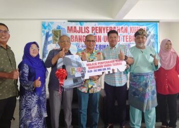 ABDUL HALIM SULEIMAN (tengah) menerima replika kunci Bangunan UMNO Bahagian Tebrau daripada Mohd. Zain di Johor Bahru.