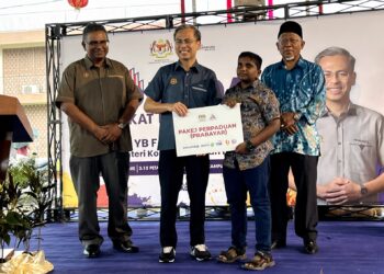 FAHMI Fadzil menyampaikan Pakej Perpaduan (Prabayar) kepada seorang pelajar pada pelancaran program Kita Madani Peringkat Negeri Sembilan di Kampung Seri Batu 8, Labu, Seremban hari ini.-UTUSAN/ZAKKINA WATI AHMAD TARMIZI.