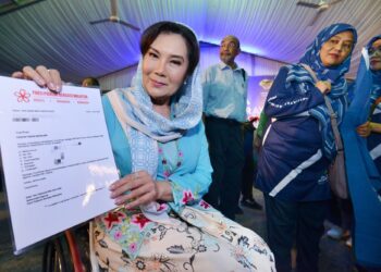 RAS Adiba Mohd. Radzi menunjukkan watikah keahlian Bersatu yang diterimanya daripada Muhyiddin pada Majlis Pelancaran Jentera PRN PN Negeri Sembilan, di Seremban, Ahad lalu.-UTUSAN/MOHD. SHAHJEHAN MAAMIN.