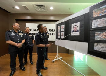 FISOL Salleh (kanan) menunjukkan gambar seorang lelaki yang dicari ekoran membuat laporan palsu berkaitan REE dalam satu sidang akhbar di IPK Kedah di Alor Setar. - UTUSAN/ SHAHIR NOORDIN