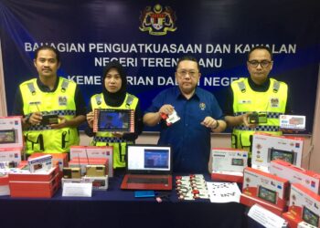 NIK Yusaimi Yussof (dua dari kanan) menunjukkan sebahagian perantik elektronik tanpa perakuan yang dirampas di Kuala Terengganu, hari ini. - UTUSAN/TENGKU DANISH BAHRI TENGKU YUSOFF