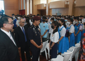 MOHD. Yusri Hassan Basri (dua dari kiri) beramah mesra dengan pelajar pada program Meniti Karier Dalam PDRM di SMJK Yuk Choy di Ipoh hari ini. - UTUSAN
