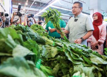 Salahuddin Ayub melihat harga sayur kangkung yang ditawarkan oleh pasar raya Econsave Setapak Sentral ketika membuat tinjauan semalam. - UTUSAN/AFIQ RAZALI