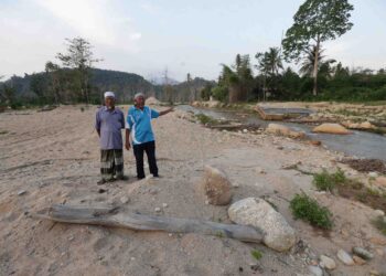ABD. Rahman Said (kanan) bersama Ahmad Lateh berada di tapak asal rumah mereka yang lenyap akibat tragedi kepala air di Kampung Iboi, Kupang di Baling.