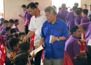 AHMAD Said menyampaikan bantuan pendidikan kepada pada majlis perasmian Program Agihan BPPS di Felda Neram 2, Kemaman, hari ini. - UTUSAN/NIK NUR IZZATUL HAZWANI NIK ADNAN