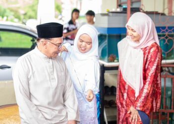 NURUL Izzah Mohammad mengambil ukuran badan Anwar Ibrahim untuk tempahan baju Melayu.