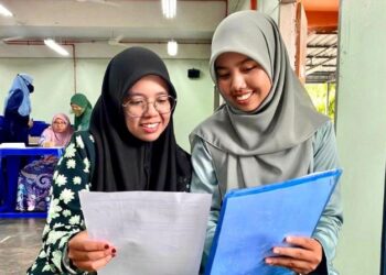 NOR Syamimi Awatif Araman (kiri) dan Khairunnisa Che Roslan (kanan) melihat surat tawaran yang diterima menyambung pengajian ke tingkatan enam SMK Syed Sirajuddin, Kangar, Perlis, semalam. - UTUSAN/ASYRAF MUHAMMAD
