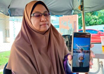 IBU Allahyarham Konstabel Muhamad Irfan Irham Badrul Hisam, Norizan Idris menunjukkan gambar anaknya yang meninggal dunia akibat strok haba.