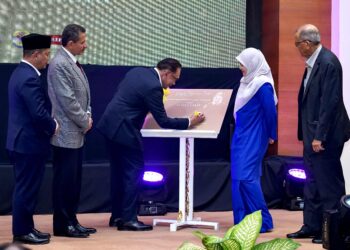 Anwar Ibrahim menandatangani plak peluncuran buku Syeikh Yusuf Al Qaradawi bertajuk “Sang Pelita Umat” di Kuala Lumpur, semalam. - UTUSAN/AMIR KHALID