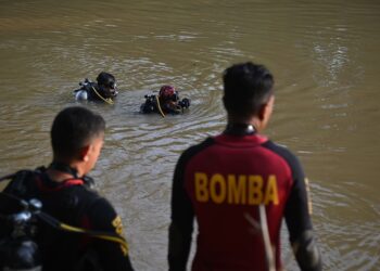 ANGGOTA Unit Selam Skuba Jabatan Bomba dan Penyelamat melakukan operasi SAR mencari mangsa kepala air di Jeram Mawar, Air Putih, Kemaman, hari ini. - UTUSAN/PUQTRA HAIRRY ROSLI