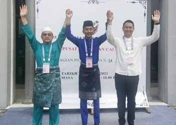 TIGA calon yang yang bertanding di DUN Bandar,  Armi Irzan Mohd. (tengah), Ahmad Shah Mohamed dan Luqman Long mengangkat tangan selepas diumumkan calon DUN Bandar di Kuala Terengganu, hari ini. - UTUSAN/KAMALIZA KAMARUDDIN