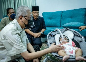 ISMAIL Sabri Yaakob (kiri) melihat keadaan  Sufi Syafrina Mohd. Shafiq, 6 bulan yang menghidap Spinal Muscular Atrophy (SMA) Saraf Genetik Type 1 ketika menziarahi bayi tersebut di Sungai Kantan di sini, hari ini.-UTUSAN/MUHAMAD IQBAL ROSLI