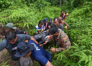 ANGGOTA pasukan mencari dan menyelamat mengusung mayat salah seorang mangsa lemas dalam kejadian kepala air di Jeram Mawar, Air Putih, Kemaman, Terengganu. - UTUSAN/PUQTRA HAIRRY