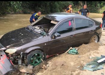 ANGGOTA polis memeriksa keadaan kereta mangsa yang ditimbus lumpur ekoran tragedi kepala air di Jeram Mawar, Air Putih, Kemaman, Sabtu lalu.