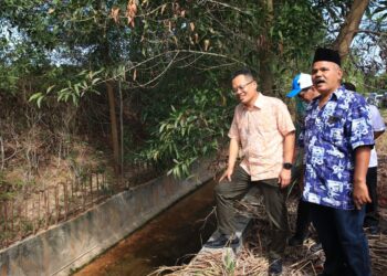 NIK Nazmi Nik Ahmad (kiri) semasa mengadakan lawatan kerja ke projek menaik taraf sistem saliran di Taman Wadi Iman, Kok Lanas, Kelantan. - UTUSAN/KAMARUL BISMI KAMARULZAMAN