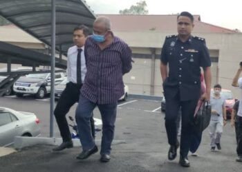 NASARUDIN Mahmud (tengah) dibawa ke Mahkmah Sesyen Kuala Pilah hari ini bagi didakwa atas pertuduhan memperdayakan seorang lelaki berkenaan tawaran tender projek kerajaan bernilai RM8 juta pada bulan Oktober tahun lalu.-UTUSAN/NOR AINNA HAMZAH.