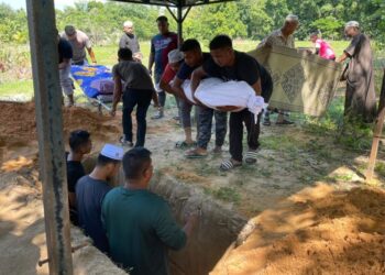 JENAZAH mangsa tersangkut di atas pokok keruing dikebumikan di Tanah Perkuburan Islam Telosan, Pasir Puteh, Kelantan semalam. – UTUSAN/ TOREK SULONG