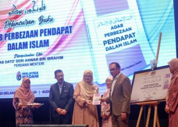 ANWAR Ibrahim menerima buku Adab Perbezaan Pendapat Dalam Islam pada majlis peluncuran buku tersebut di Kompleks Islam Putrajaya. - UTUSAN/FAISOL MUSTAFA