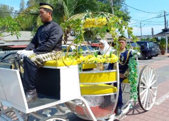 SHARIPAH MOHD. dan Ishak Ismail menaiki kereta kuda sejauh satu kilometer sempena meraikan majlis persaraannya di Puteri Qashrina Chalet, Pantai Puteri, Melaka. - UTUSAN/AMRAN MULUP