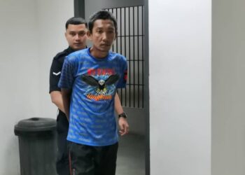 TERTUDUH diiring oleh polis semasa hadir untuk sesi perbicaraan di  Mahkamah Majistret, Kota Bharu, Kelantan hari ini-UTUSAN/ROSALWANI CHE SOH