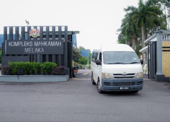 VAN putih yang membawa suspek keluar dari Kompleks Mahkamah Ayer Keroh, Melaka selepas perintah reman dikeluarkan selama tujuh hari. - UTUSAN/SYAFEEQ AHMAD