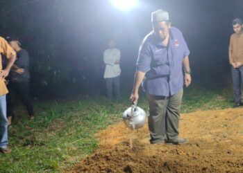ABANG kepada Allahyarham iaitu Wan Mohd Faizal Wan Alias menyiram air di pusara adiknya yang selamat dikebumikan di Tanah Perkuburan Islam Kampung Bintongan, Rembau tengah malam tadi.-UTUSAN/NOR AINNA HAMZAH.